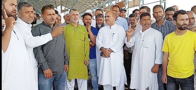 Fruit growers and dealers protest at Sopore fruit mandi over halting of trucks on NH-44